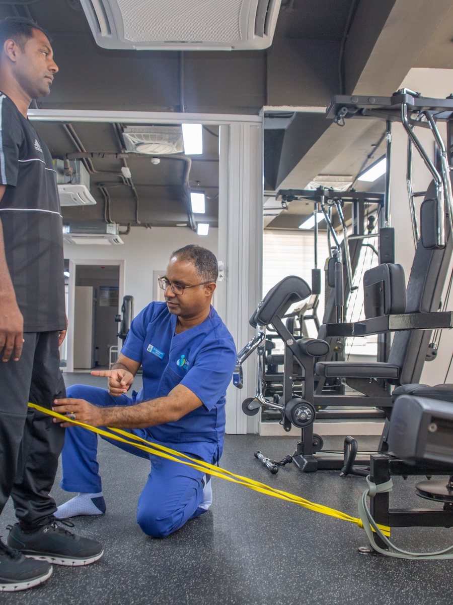Physiotherapist guiding patient with resistance band